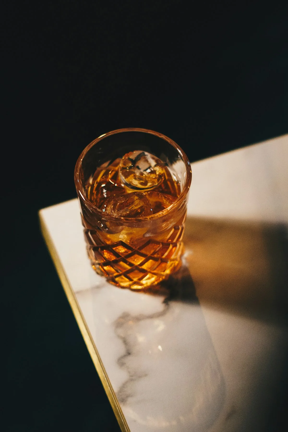 A restrained house cocktail in a cut rocks glass.
